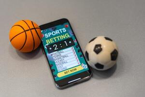 smartphone met toepassing voor sport weddenschappen en een basketbal bal, concept van online weddenschappen foto
