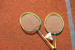 badminton shuttles en racket, geplaatst in de hoek van een synthetisch veld. foto