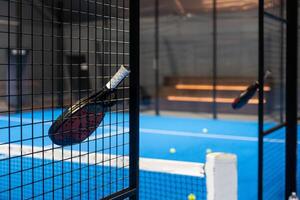 detailopname visie van een peddelen racket in een padel tennis rechtbank in de buurt de netto. sport, Gezondheid, jeugd en vrije tijd concept. sportief apparatuur. wit lijnen in achtergrond foto