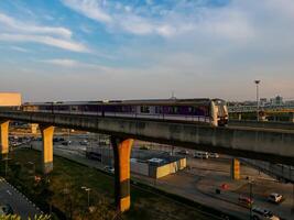 nonthaburi-thailand april 16, 2024 de elektrisch lucht trein mrt Purper lijn passeert door centraal westgate afdeling op te slaan de grootste boodschappen doen plein in de avond Bij knal ja, nonthaburi Thailand. foto