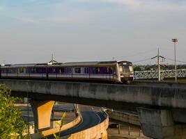 nonthaburi-thailand april 16, 2024 de elektrisch lucht trein mrt Purper lijn passeert door centraal westgate afdeling op te slaan de grootste boodschappen doen plein in de avond Bij knal ja, nonthaburi Thailand. foto