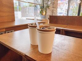 twee bevroren koffie Aan een cafe tafel met modern decor foto