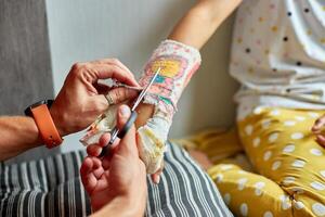 vader Verwijderen een gips gips tiener meisje met een gebroken arm foto