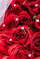 een chique wit goud verloving ring met een rood leven roos en parel achtergrond. mockup van een ansichtkaart, uitnodiging, omslag. bruiloft ontwerp. top visie foto