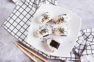 dichtbij omhoog van onigiri traditioneel Japans voedsel van rijst- en tonijn Aan een bord Aan de tafel top visie foto