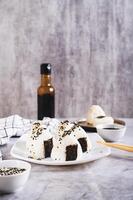 onigiri traditioneel Japans voedsel van rijst- en tonijn Aan een bord Aan de tafel verticaal visie foto