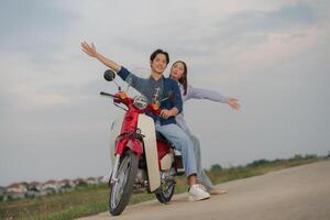 jong paar genieten van een motorfiets rijden Bij schemer foto