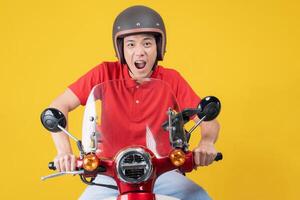 gelukkig levering rijder Aan rood motorfiets met geel achtergrond foto