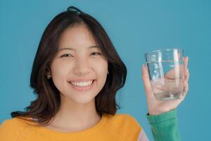 vrolijk vrouw Holding een glas van water foto
