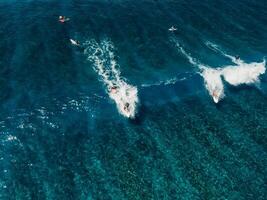 antenne visie met surfing Aan Golf. perfect golven met surfers in tropisch oceaan foto