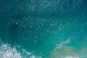 surfers met surfplanken in blauw oceaan aan het wachten Golf. antenne visie foto