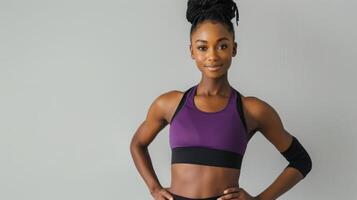 vrouw in een Purper sport- beha en zwart leggings staand met handen Aan heupen foto