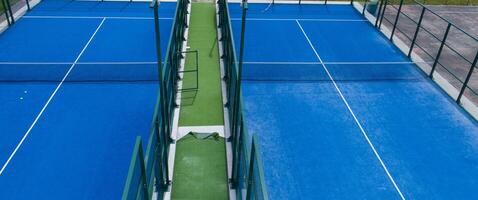 twee blauw synthetisch gras peddelen tennis rechtbanken foto