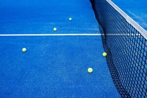 vijf ballen Aan een blauw peddelen tennis rechtbank in de buurt de netto, racket sport- concept foto