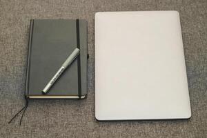 laptop serie vlak metaal Aan de tafel met een bedrijf dagboek. foto