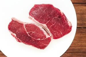 een stuk van premie vlees, striploin steak Aan een houten tafel foto