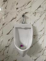 dichtbij omhoog van urinoir mannen openbaar toilet, detailopname wit urinoir in Mannen badkamer foto