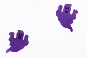 papier geesten Aan een Purper achtergrond, halloween concept foto