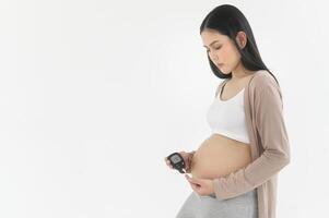 zwanger vrouw controle bloed suiker niveau door gebruik makend van digitaal glucose meter, Gezondheid zorg, geneesmiddel, suikerziekte, glycemie concept foto