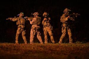 soldaten in camouflage uniformen het richten met hun geweren klaar naar brand gedurende leger operatie Bij nacht, soldaten opleiding in een leger operatie foto