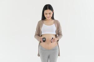 zwanger vrouw controle bloed suiker niveau door gebruik makend van digitaal glucose meter, Gezondheid zorg, geneesmiddel, suikerziekte, glycemie concept foto