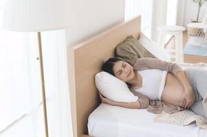 zwanger vrouw slapen Aan de bed, zwangerschap en verwachting concept foto