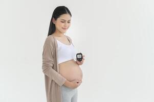 zwanger vrouw controle bloed suiker niveau door gebruik makend van digitaal glucose meter, Gezondheid zorg, geneesmiddel, suikerziekte, glycemie concept foto