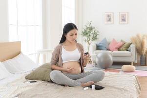 zwanger vrouw controle bloed suiker niveau door gebruik makend van digitaal glucose meter, Gezondheid zorg, geneesmiddel, suikerziekte, glycemie concept foto