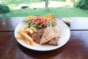 varkensvlees steak en kip steak met Frans Patat ,brood en salade of gegrild varkensvlees en gegrild kip foto