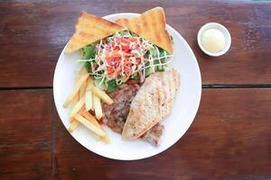 varkensvlees steak en kip steak met Frans Patat ,brood en salade of gegrild varkensvlees en gegrild kip foto