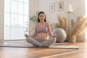 gezond zwanger vrouw oefenen en aan het doen prenataal yoga, meditatie, werken uit, yoga, zwangerschap concept. foto