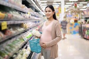 mooi zwanger vrouw boodschappen doen gezond voedsel Bij kruidenier winkel foto