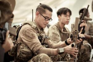 soldaten in camouflage uniformen planning Aan operatie in de kamp, soldaten opleiding in een leger operatie foto