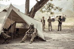 soldaten in camouflage uniformen planning Aan operatie in de kamp foto