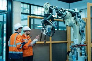 een groep van robotica ingenieurs werken met programmering en manipuleren robot hand, industrieel robotica ontwerp, hoog tech faciliteit, modern machine aan het leren. massa productie automaten. foto