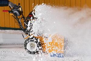 een ervaren arbeider sneeuw blazer naar efficiënt Doorzichtig sneeuw na storm, effectief slagen weg sneeuw foto