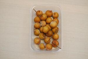 longan fruit in plastic doos Aan hout tafel, top visie. foto