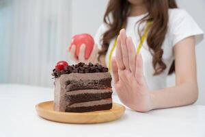 schoonheid slank vrouw lichaam verwarren chocola taart. vrouw in restaurant behaalt gewicht verlies doel voor gezond leven, gek over dunheid, dun taille, voedingsdeskundige. eetpatroon, lichaam vorm geven aan. foto