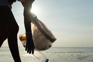 opslaan water. vrijwilliger plukken omhoog uitschot vuilnis Bij de strand en plastic flessen zijn moeilijk ontleden voorkomen kwaad aquatisch leven. aarde, omgeving, vergroening planeet, verminderen globaal opwarming, opslaan wereld foto