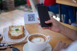 vrouw gebruik smartphone naar scannen qr code naar betalen in cafe restaurant met een digitaal betaling zonder contant geld. Kiezen menu en bestellen accumuleren korting. e portemonnee, technologie, betalen online, credit kaart, bank app. foto