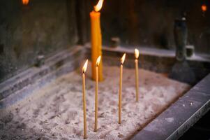 brandend kaarsen Aan zand, lit voor geliefde degenen foto
