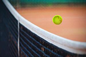 tennis bal over- de netto foto