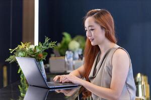 Aziatisch bedrijf vrouw in formele kleding gebruik makend van laptop computer terwijl werken in klein cafe voor werken van huis en online onderwijs concept foto