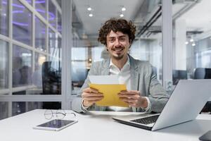 portret van gelukkig volwassen investeerder zakenman in kantoor, Mens op zoek Bij camera en geschokt gelukkig en lachend, baas opening envelop met mooi zo nieuws kennisgeving foto