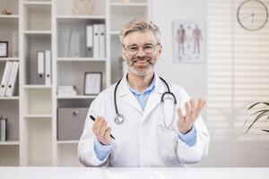 portret van een senior mannetje dokter en leraar wie voert online opleiding voor medisch Universiteit studenten via telefoongesprek. leest een lezing, voert een Cursus, duurt examens van een afstand. foto