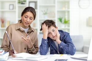 schattig en saai studie Bij huis, mam legt uit huiswerk naar zoon, familie studie Bij huis zittend in leven kamer, zoon niet begrijpen huiswerk van streek en verveeld. foto