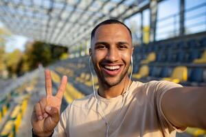 sportman loper in stadion nemen selfie foto en pratend Aan telefoontje met vrienden, spaans Mens op zoek Bij camera en glimlachen opname sport- blog, jong Mens na actief opleiding.