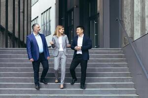 verschillend bedrijf team Mens en vrouw wandelen samen Aan trap buiten kantoor gebouw, bedrijf mensen nemen een wandelen Aan breken en hebben pret pratend foto