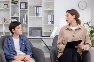 een pediatrisch psycholoog overlegt een tiener- jongen, werken binnen een medisch overleg plegen kamer. foto