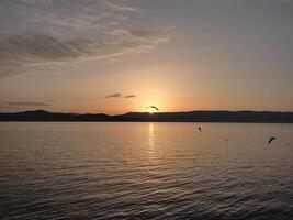 zonsopkomst over- monteren galichica gezien van de kust van meer ohrid in kalishta klooster, Macedonië foto
